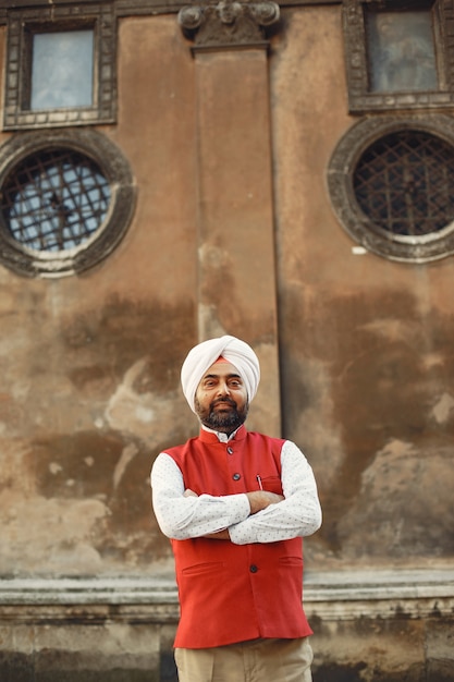 Foto grátis homem indiano em uma cidade. macho em um turbante tradicional. hinduísta em uma cidade de verão.