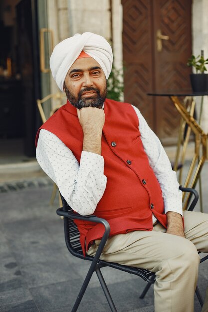 Homem indiano em uma cidade. Macho em um turbante tradicional. Hinduísta em uma cidade de verão.