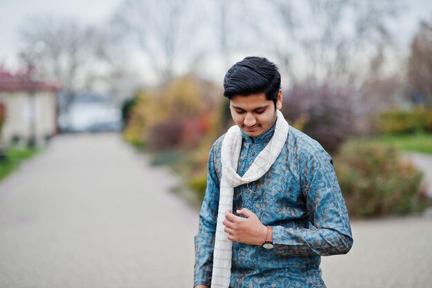 Homem indiano usa roupas tradicionais com lenço branco posado ao ar livre