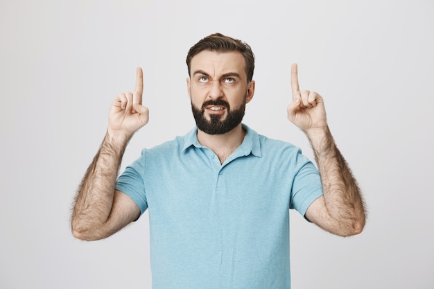 Homem irritado com uma careta apontando o dedo e parecendo zangado