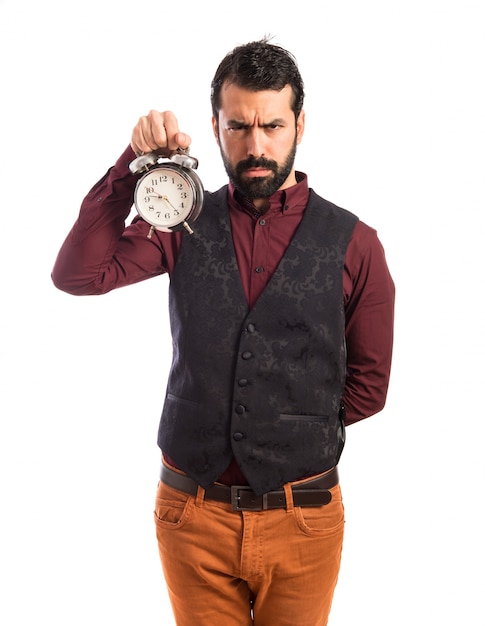 Homem irritado, vestindo o colete, segurando relógio vintage