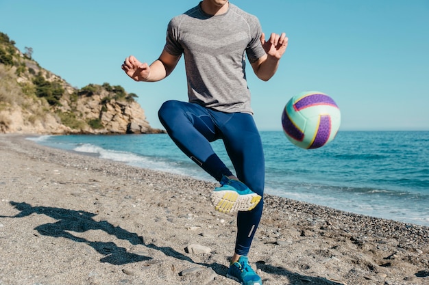 Homem, jogando futebol, praia