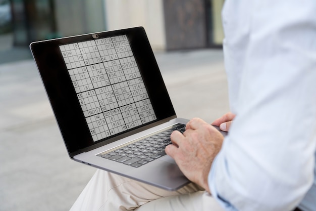 Foto grátis homem jogando sudoku em seu laptop