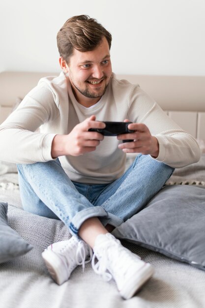 Homem jogando videogame em casa, foto completa