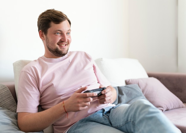 Homem jogando videogame no sofá