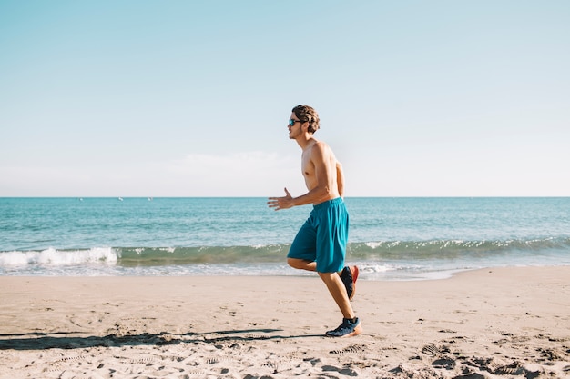 Homem jogging na praia