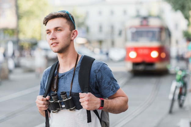 Foto grátis homem jovem, com, binóculos, ligado, rua