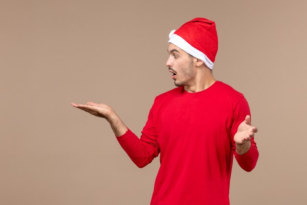 Homem jovem com cara de surpresa no fundo marrom cor masculina emoção férias