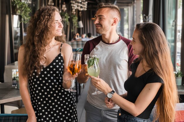 Homem jovem, com, dois, femininas, amigos, brindar, bebidas