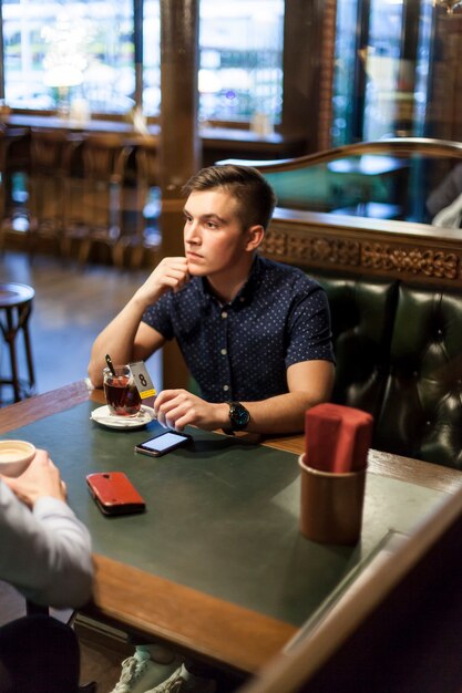 Homem jovem, com, xícara chá, em, restaurante