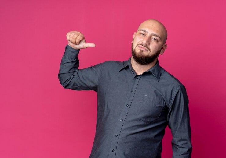Foto grátis homem jovem confiante e careca de call center apontando para si mesmo, isolado em vermelho com espaço de cópia
