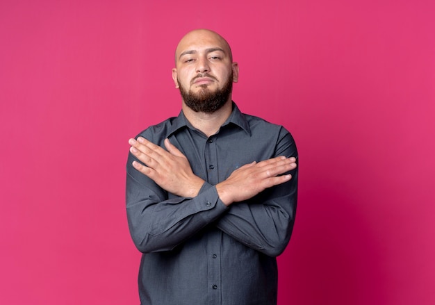 Foto grátis homem jovem confiante e careca de call center, de mãos cruzadas, isoladas em vermelho com espaço de cópia