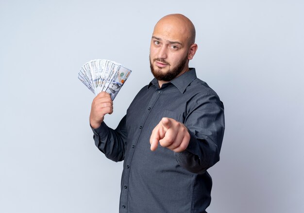 Homem jovem e careca de call center em vista de perfil segurando dinheiro isolado no fundo branco com espaço de cópia