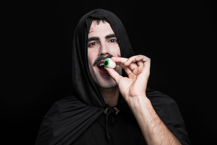 Foto grátis homem jovem, em, traje halloween, posar, em, estúdio, com, artificial, olho