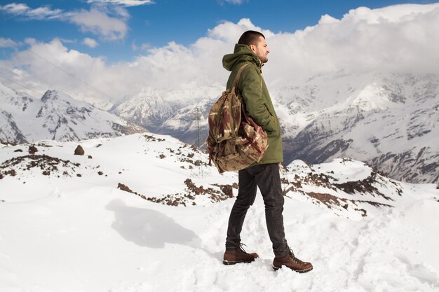 Homem jovem hippie caminhando nas montanhas, viagem de férias de inverno