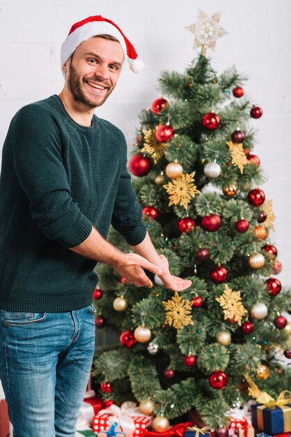 Homem jovem, mostrando, árvore natal