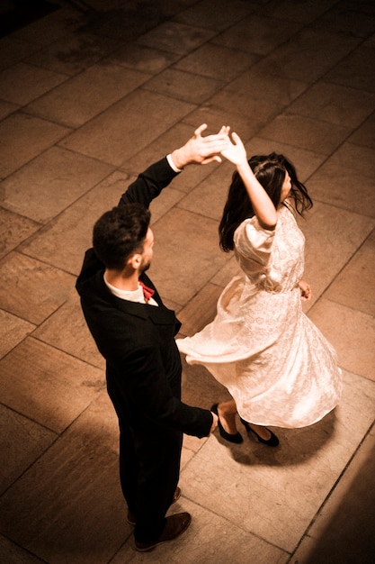 Foto grátis homem jovem, segurando mão, de, whirling, elegante, mulher