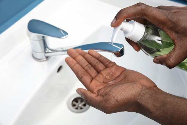 Homem lavando as mãos com cuidado no banheiro fecha prevenção de infecção
