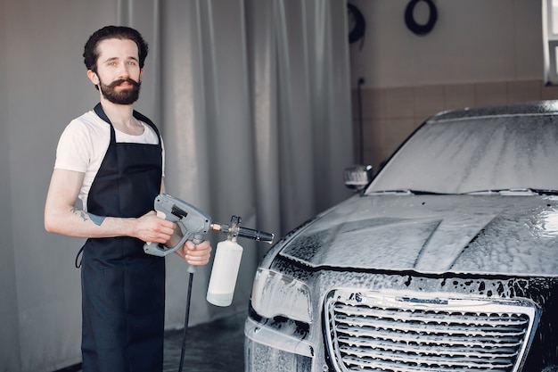 Homem lavando o carro em uma garagem