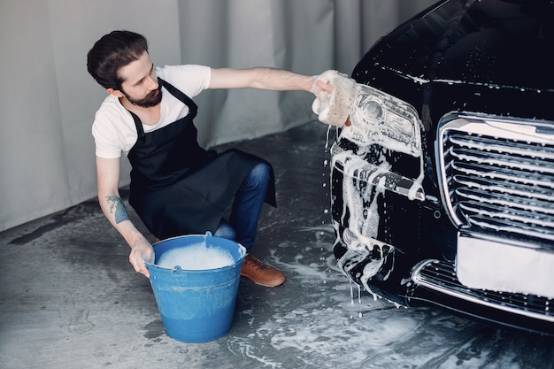 Homem lavando o carro em uma garagem