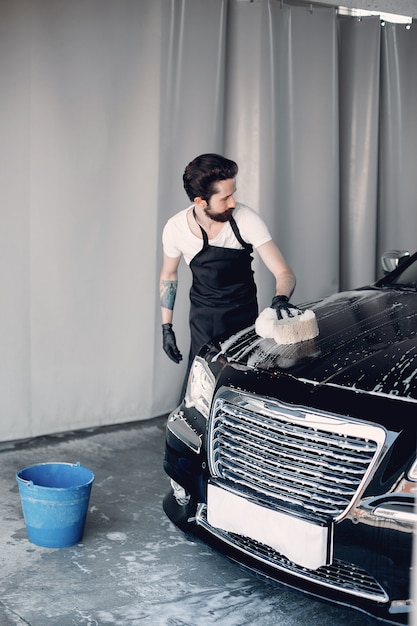 Foto grátis homem lavando o carro em uma garagem