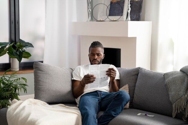 Homem lendo as instruções para um teste cobiçoso em casa