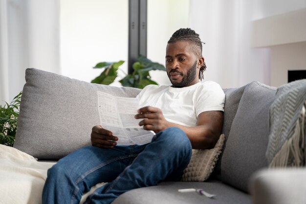 Homem lendo as instruções para um teste cobiçoso em casa