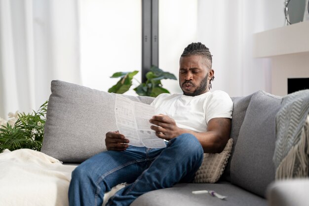 Homem lendo as instruções para um teste cobiçoso em casa