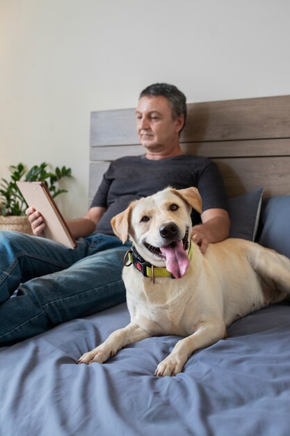 Homem lendo em casa com seu companheiro de cachorro