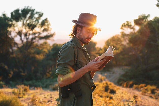 Homem lendo livro no campo