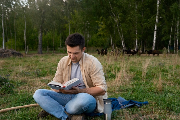 Homem lendo tiro completo ao ar livre