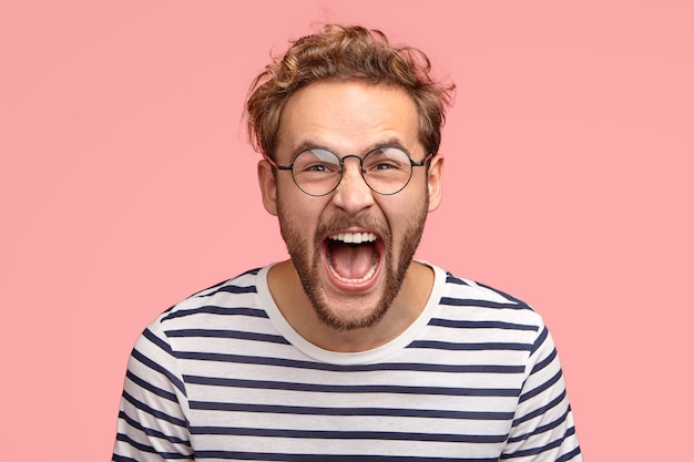 Homem louco gritando alto, com expressão facial de alegria