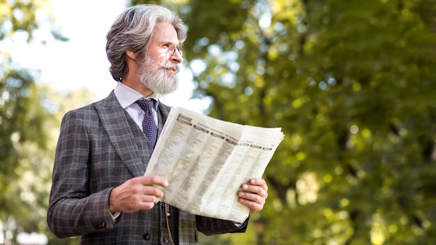 Homem maduro elegante segurando jornal