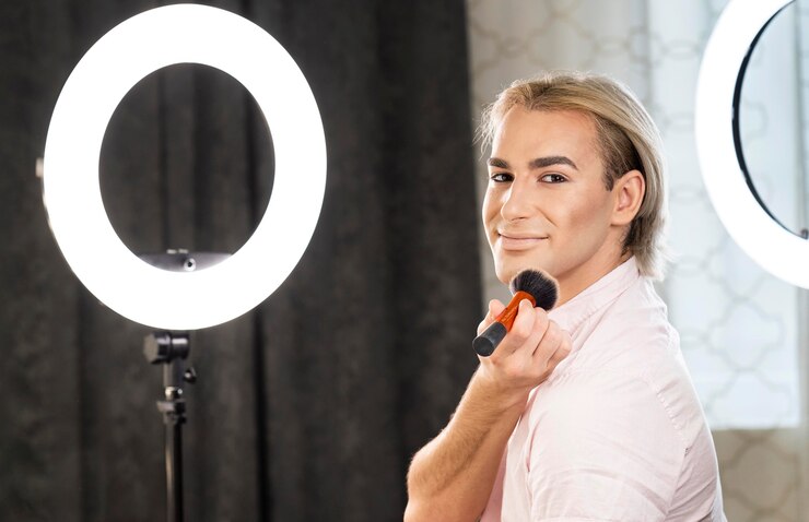 Foto grátis homem maquiado sentado ao lado do espelho de luz