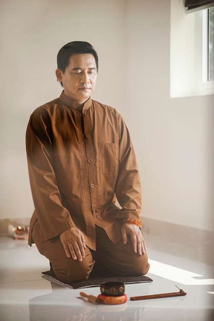 Homem meditando com tigela de canto e incenso