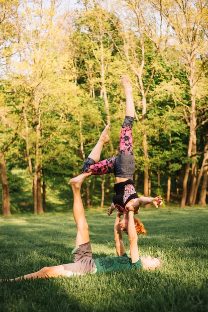 Foto grátis homem, mentir grama, e, equilibrar, mulher, mão, e, perna, parque