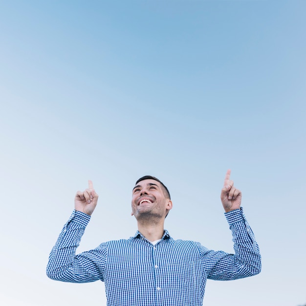 Foto grátis homem moderno apontando para cima