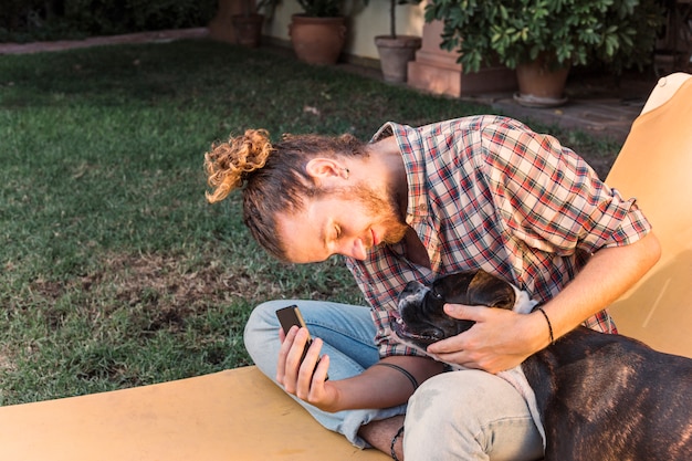 Foto grátis homem moderno com cachorro no jardim