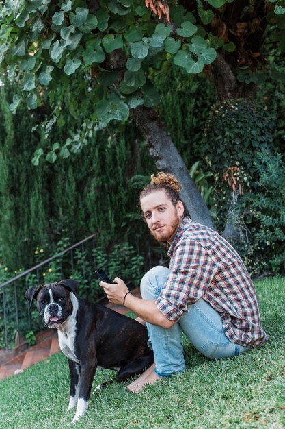 Homem moderno com cachorro no jardim