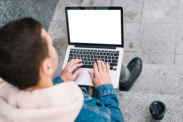 Homem moderno, usando computador portátil, em, urbano, meio ambiente