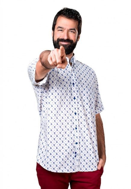 Foto grátis homem moreno bonito com barba apontando para a frente