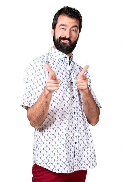 Foto grátis homem moreno bonito com barba apontando para a frente