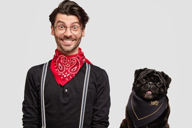 Foto grátis homem moreno estiloso com lenço vermelho ao lado do cachorro