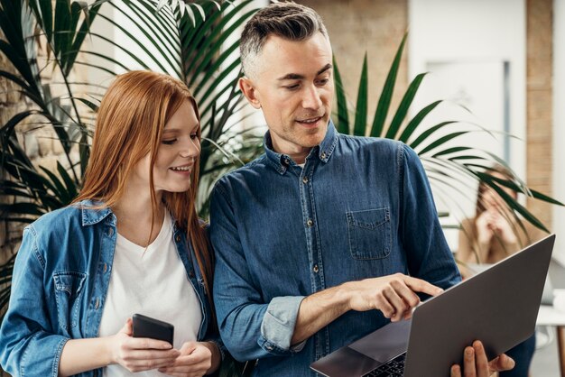 Homem mostrando algo em um laptop para seu colega de trabalho