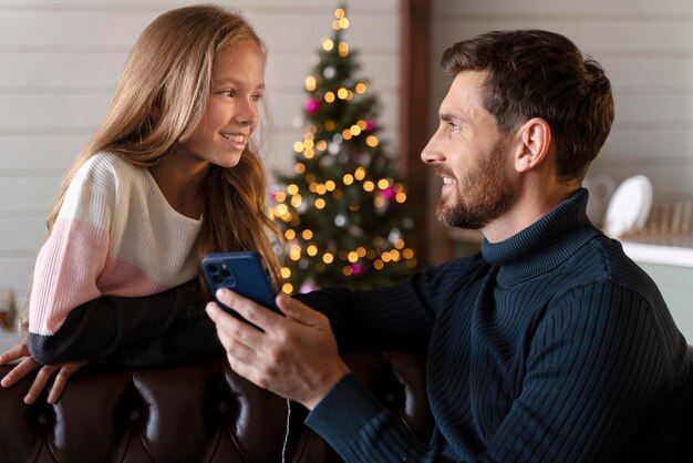 Homem mostrando algo para a filha em seu smartphone