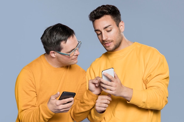 Foto grátis homem mostrando algo para seu melhor amigo no telefone