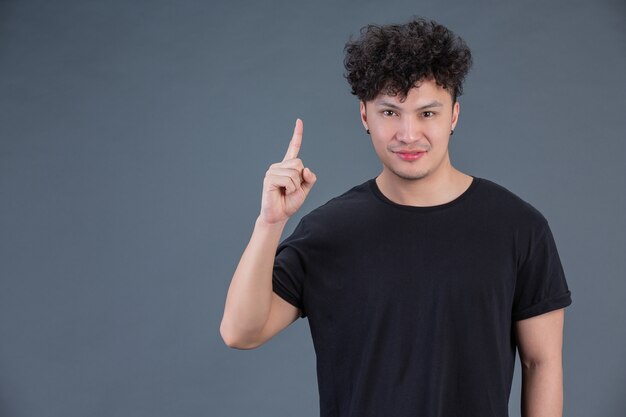 Homem mostrando o gesto com a mão no estúdio por trás posando