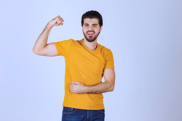 Homem mostrando os músculos do braço e se sentindo poderoso.