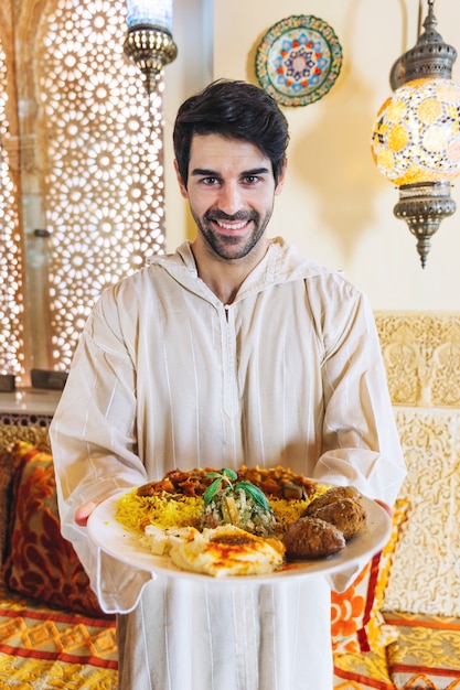 Foto grátis homem, mostrando, prato, de, alimento árabe