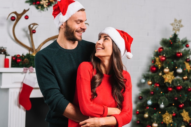 Homem, mulher abraçando, em, natal, chapéu